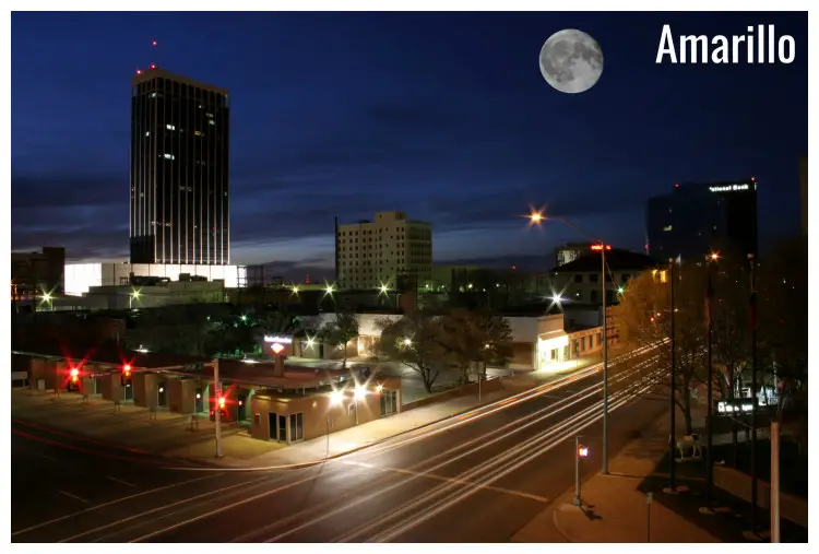 Street lights shine bright in the night with a view of the scenic full moon up in Amarillo, Texas Street lights shine bright in the night with a view of the scenic full moon up in Amarillo, Texas