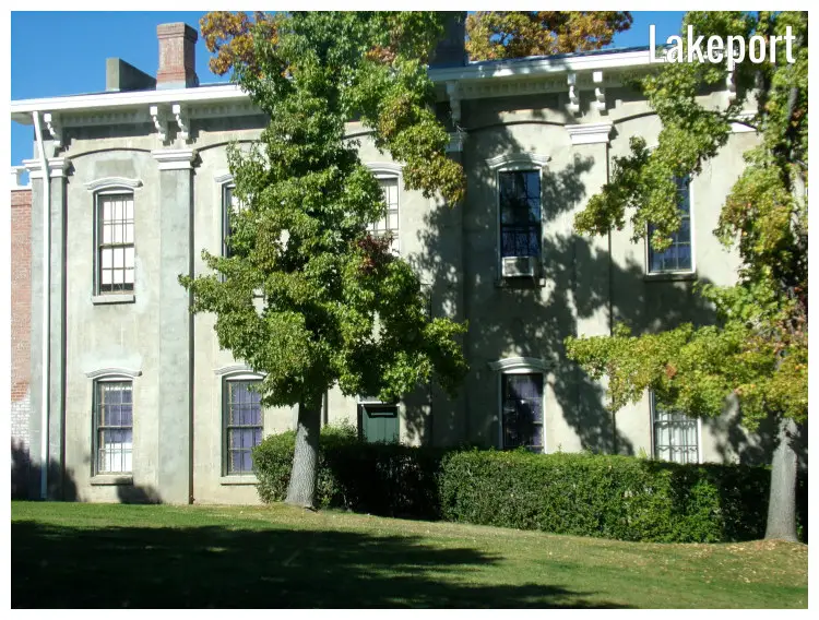 An intricately designed house surrounded by a natural fence, trees, and neat lawns in Lakeport, California