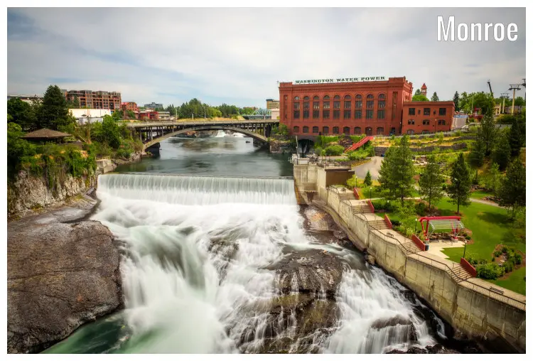 The red Washington Water Powerhouse, next to a large bridge over the Spokane River and scenic waterfalls in Monroe, Washington