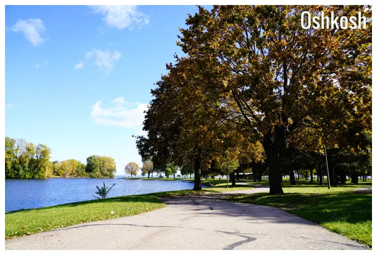 A beautiful nature park with many trees and neat lawns next to a calm pond in Oshkosh, Wisconsin A beautiful nature park with many trees and neat lawns next to a calm pond in Oshkosh, Wisconsin