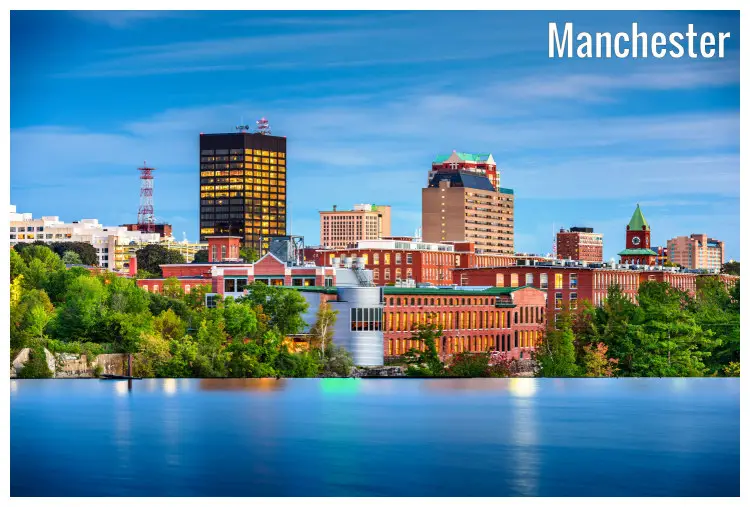 The colorful buildings in the city of Manchester, New Hampshire, right next to scenic trees on the seashore, a beautiful glass image in the river below The colorful buildings in the city of Manchester, New Hampshire, right next to scenic trees on the seashore, a beautiful glass image in the river below