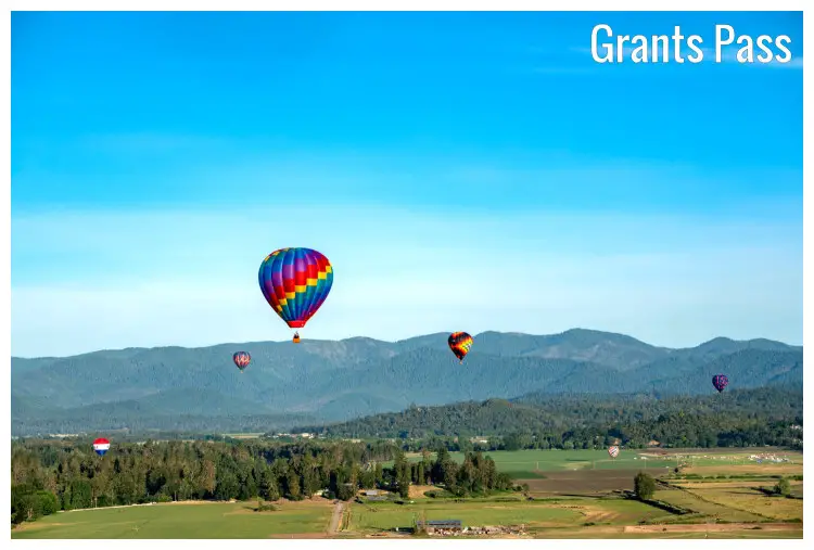 Colorful balloons rise from the scenic grounds in a field near Grant Pass, Oregon Colorful balloons rise from the scenic grounds in a field near Grant Pass, Oregon