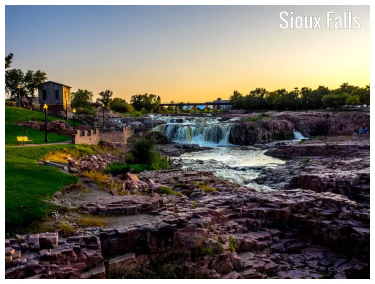 The Sioux Falls in South Dakota, flowing downstream over rocks under the perfect evening skyline The Sioux Falls in South Dakota, flowing downstream over rocks under the perfect evening skyline