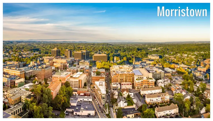 Downtown Morristown, New Jersey, in a perfect aerial shot of the rest of the city, the green tree cover, and the stunning colorful clear sky above