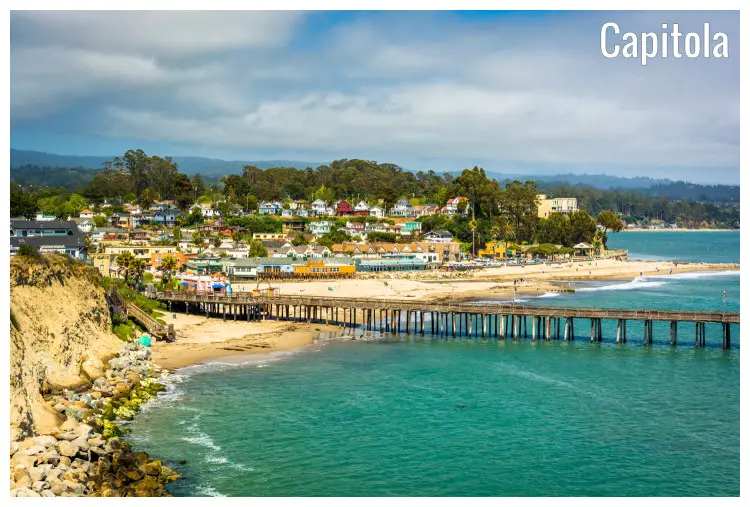 The beach and a long wooden pier on the calm blue waters in Capitola, California The beach and a long wooden pier on the calm blue waters in Capitola, California