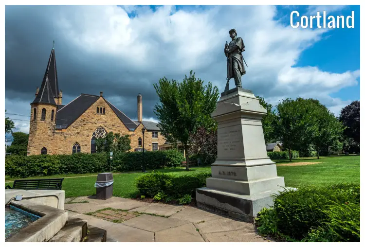 A monument from the civil war stands high in the neat lawns near the iconic courthouse in the Courthouse Park in Cortland, New York A monument from the civil war stands high in the neat lawns near the iconic courthouse in the Courthouse Park in Cortland, New York