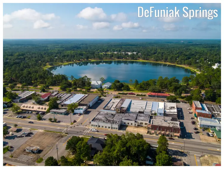 DeFuniak Springs Lake in Florida, with a view of the surrounding forestry and houses