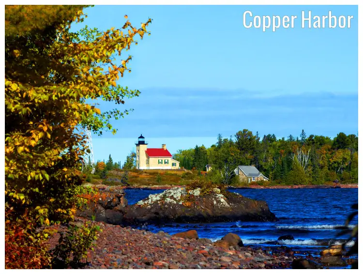 A colorful lighthouse of the Copper Harbor, Michigan, with a stunning waterfront full of pebbles and rocks