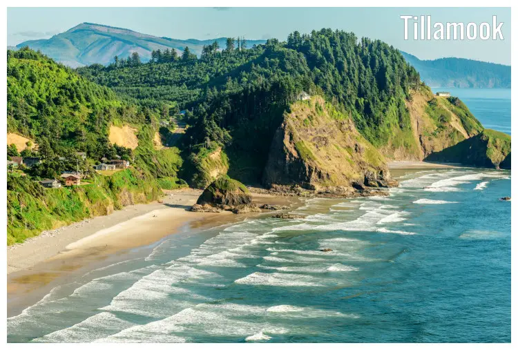 A beach on the Oregon Coastline in Tillamook, below a unique scenery of seaside homes, large rocks, cliffs, and far hilly ranges