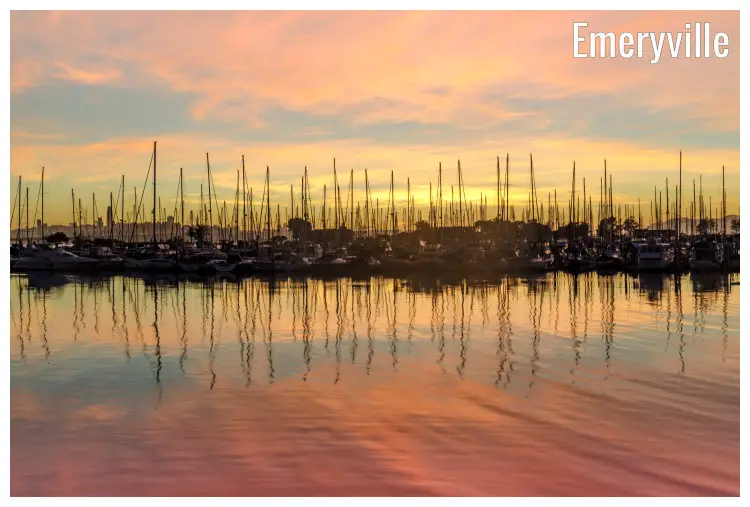 Colorful sky at dusk, with stunning water reflection of numerous boats, docked on the San Francisco Bay in Emeryville, California