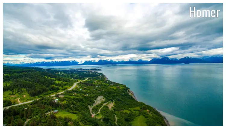 The scenic Homer Spit region in Homer, Alaska, overlooking the calm seawater and distant mountain ranges