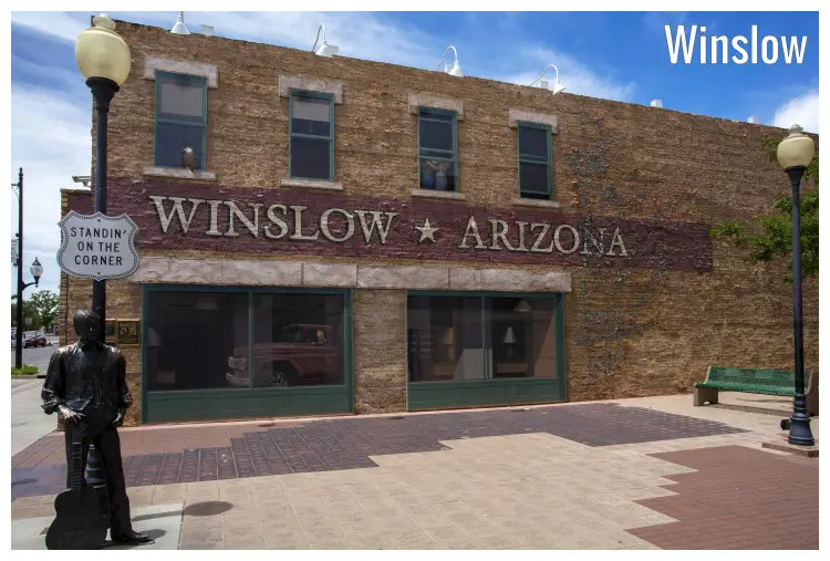 A building located in Winslow Arizona, featuring a statue of a man standing on the corner with a guitar