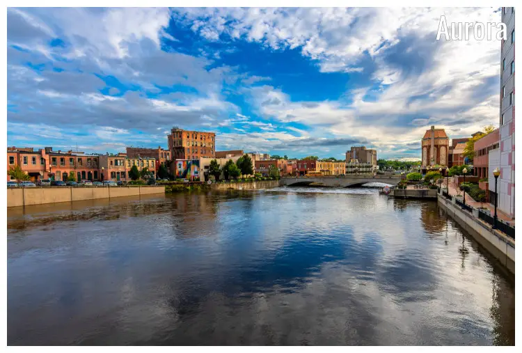 The tranquil city of Aurora, Illinois, as set in the peaceful waterfront promenade and the cloudy sky reflected in the water below The tranquil city of Aurora, Illinois, as set in the peaceful waterfront promenade and the cloudy sky reflected in the water below
