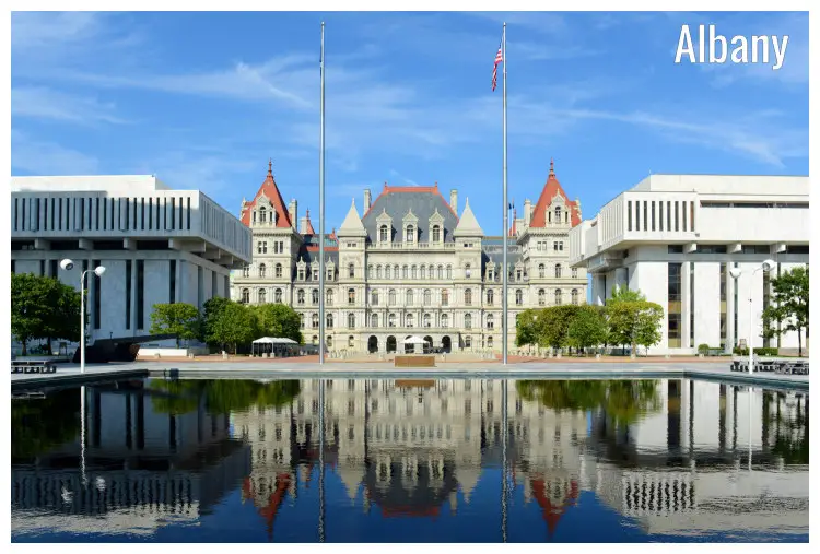 The grand State Capitol building in Albany, New York, USA, with a mirrored reflection in the waterfront