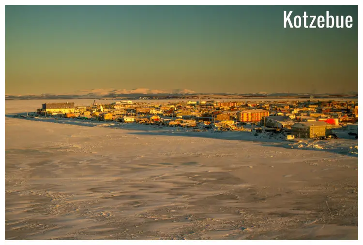 A winter day in Kotzebue Village, Alaska - the sunlit buildings and snow-peaked mountains afar A winter day in Kotzebue Village, Alaska - the sunlit buildings and snow-peaked mountains afar