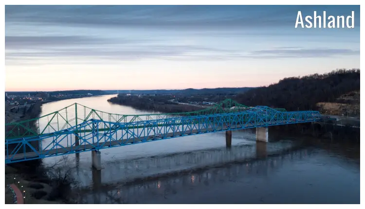 Two bridges of the same length and size, colored green and blue, cross over a large river from Ashland in Kentucky