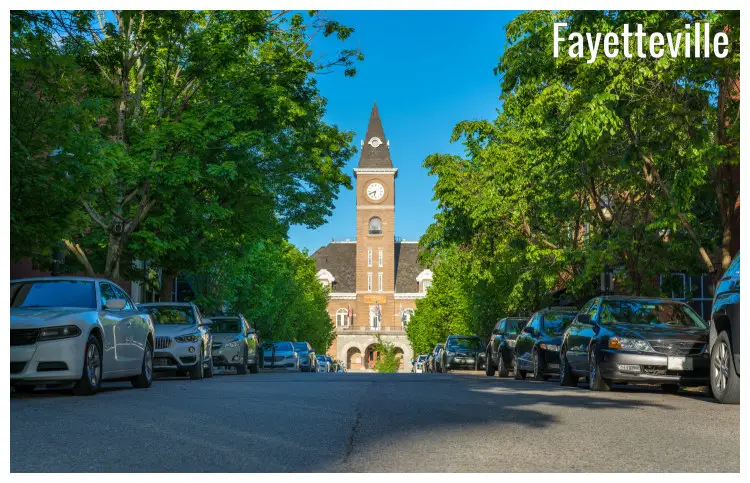 Green trees and parked cars on the roadsides of College Avenue leading to the iconic Washington County Courthouse in Fayetteville, Arkansas Green trees and parked cars on the roadsides of College Avenue leading to the iconic Washington County Courthouse in Fayetteville, Arkansas