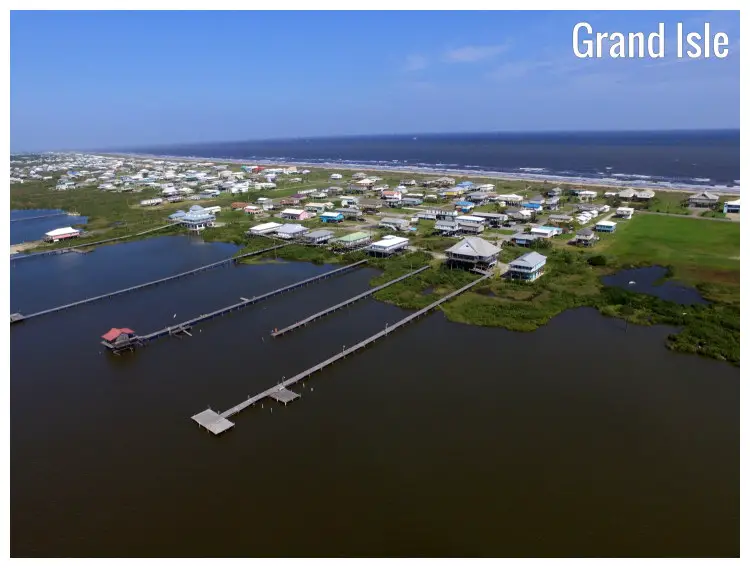 The scenic Grand Isle, Louisiana, with a view of the numerous houses and the extended piers onto the calm seawater