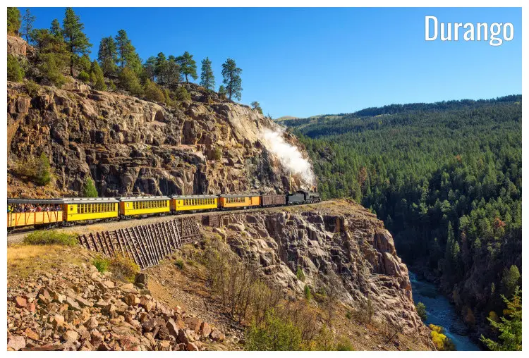 A railway passing through the high rocks and cliffs of San Juan Mountains, with an old steam engine train from Durango, Colorado to Silverton