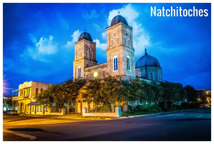 Night neon light rays fall on the ancient building that holds the Minor Basilica in Natchitoches, Louisiana