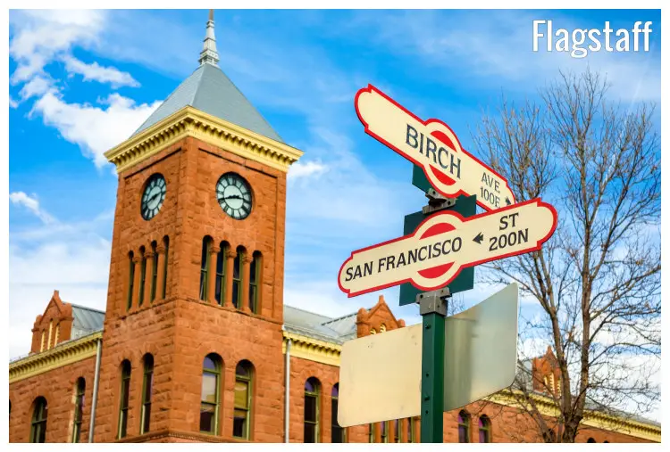 The brown iconic clock tower in the city of Flagstaff, Arizona, with the street signs of Birch Avenue and San Francisco Street