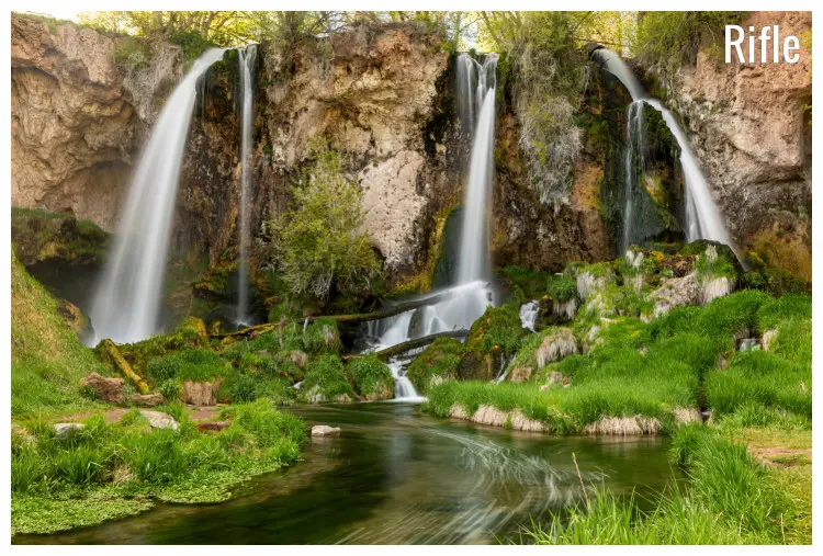 The scenic Triple Falls of the Rifle Falls in Colorado, flowing to the still waters of the river below The scenic Triple Falls of the Rifle Falls in Colorado, flowing to the still waters of the river below