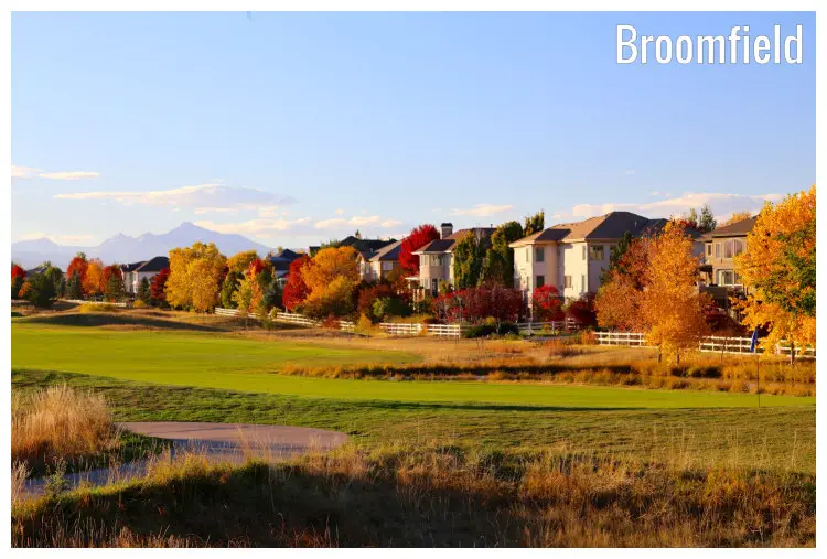 Neat and well-manicured lawns of a golf course in Broomfield, Colorado, colorful brown and golden trees amid classy homes during the fall