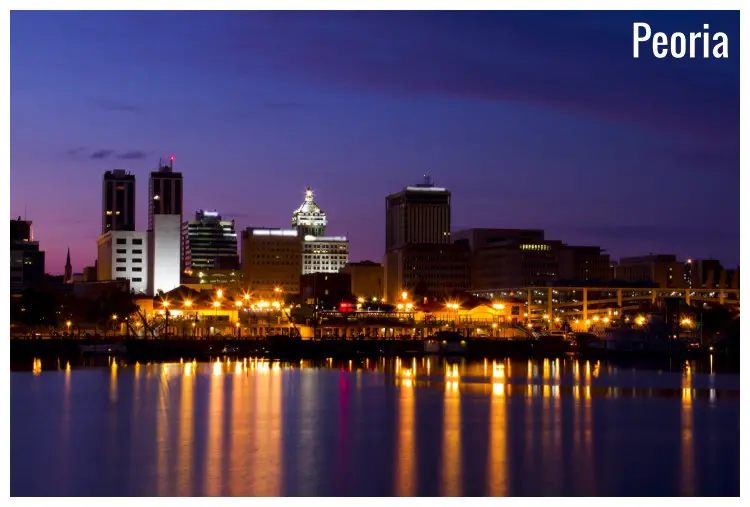 Street lights and tall buildings in the city of Peoria, Illinois, as well as the night sky reflected in the waterfront Street lights and tall buildings in the city of Peoria, Illinois, as well as the night sky reflected in the waterfront