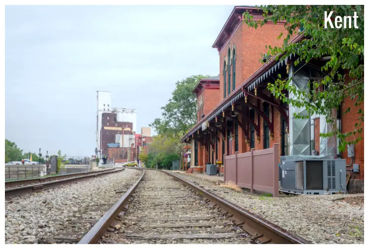 A long shot of the clear railways tracks with buildings in this railway station in the small city of Kent, Ohio
