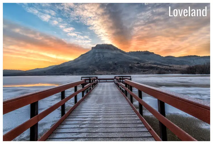 A pier over the water of the Flatiron Reservoir in Loveland facing high mountains, Colorado
