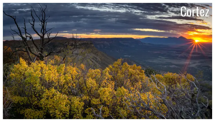 The bright and red rays of the setting sun over the scenic layout of hills and plains of Cortez, Colorado The bright and red rays of the setting sun over the scenic layout of hills and plains of Cortez, Colorado