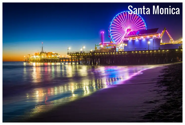 The neon-lit fun park in Santa Monica, California, with a view of the iconic Ferris wheel and pier The neon-lit fun park in Santa Monica, California, with a view of the iconic Ferris wheel and pier