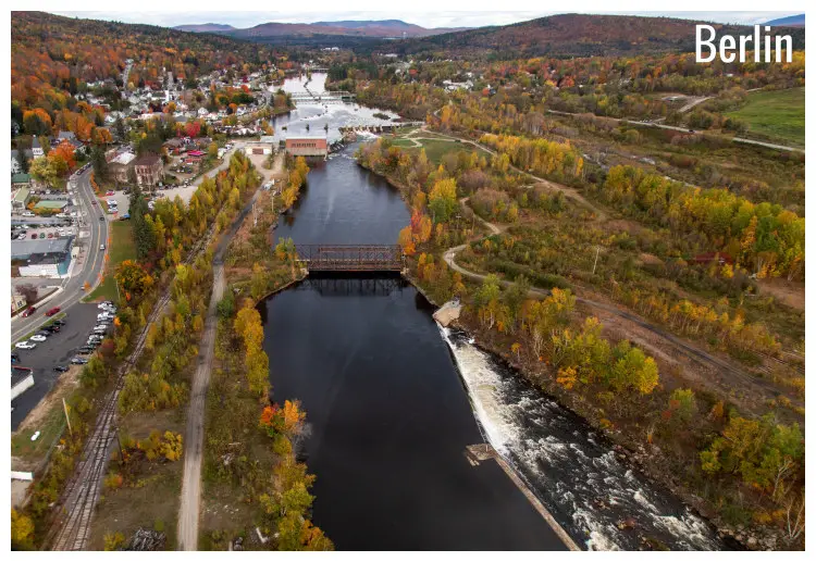 A large and long river with roads and houses along its edges in Berlin, New Hampshire A large and long river with roads and houses along its edges in Berlin, New Hampshire