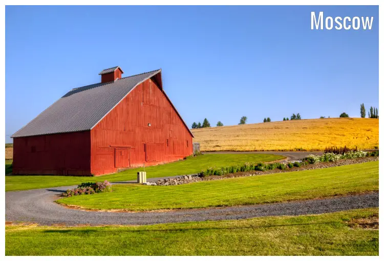 Clean paths and scenic, neat lawns surrounding lone red barn in a field in Moscow, Idaho