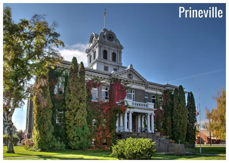 The iconic landmark of the ancient courthouse of the Crook County in Prineville, Oregon, amid many trees with the colorful fall foliage beauty The iconic landmark of the ancient courthouse of the Crook County in Prineville, Oregon, amid many trees with the colorful fall foliage beauty