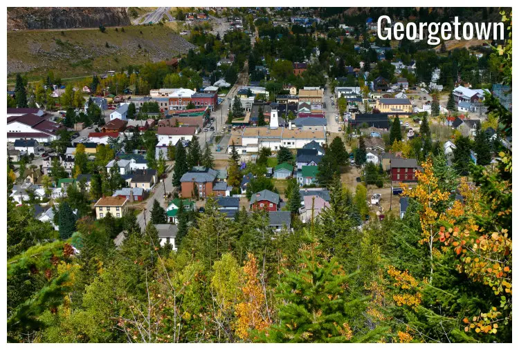The colorful houses in a village in Georgetown, Colorado, with scenic trees on hill slopes around