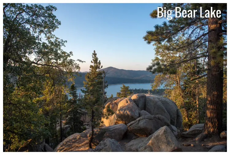 Big Bear Lake, California, with close rocks amid trees, and mountains in the distance Big Bear Lake, California, with close rocks amid trees, and mountains in the distance