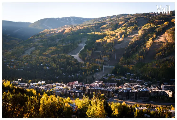 Sunrise over Vail, Colorado hitting the slope of a mountain with nearby golden colored trees and a hill in the distance Sunrise over Vail, Colorado hitting the slope of a mountain with nearby golden colored trees and a hill in the distance