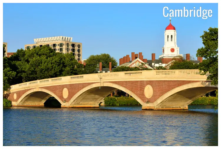 The John Weeks Memorial Footbridge in Cambridge, Massachusetts, over the Charles River calm waters, and a distant view of the Havard University student residence unit