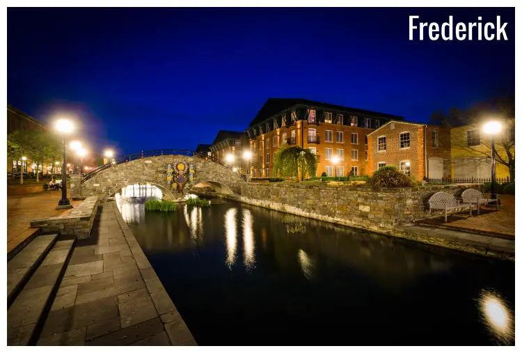 A stone bridge over the calm Carroll Creek in the Carroll Creek Linear Park in Frederick, Maryland