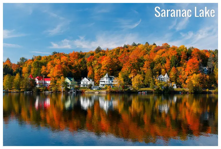 A view from the Saranac Lake, New York, of the tranquil setting around the lakeside homes amid the golden and brown trees in the fall A view from the Saranac Lake, New York, of the tranquil setting around the lakeside homes amid the golden and brown trees in the fall