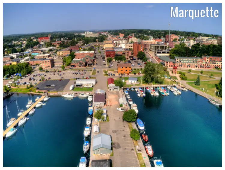 Boats docked along the piers on the vast Lake Superior and cars and buildings in the rest of Marquette City, Michigan